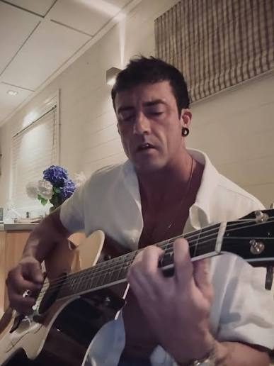 Jasper singing with acoustic guitar