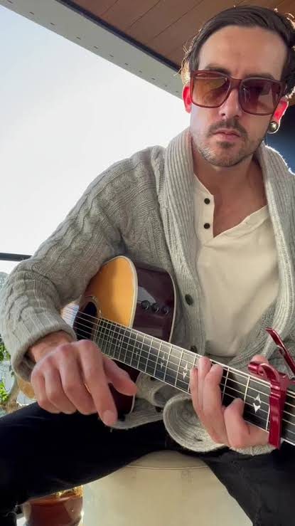 Jasper with acoustic guitar and sunglasses