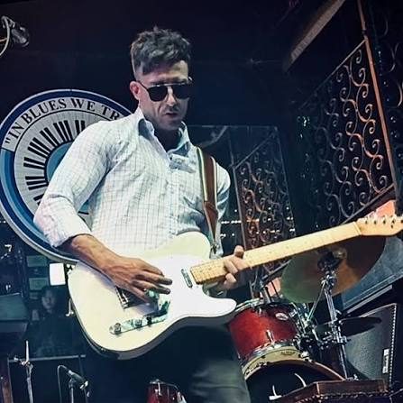 Jasper on stage with a white electric guitar